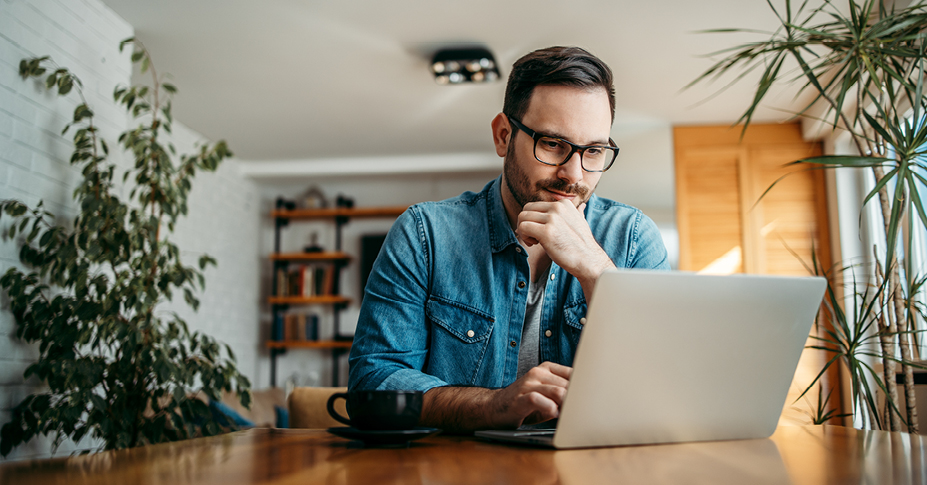 Riding out turbulent times with alternative investments - man looking at his portfolio on his computer.