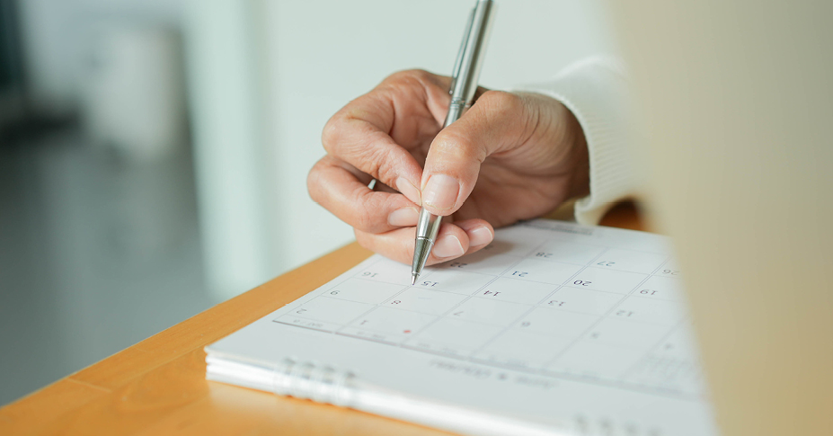 hand marking a calendar