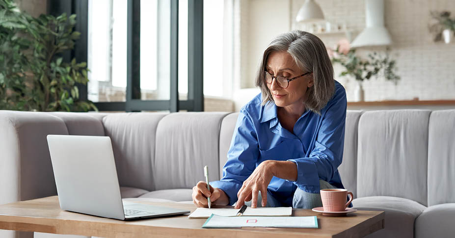Woman sitting on couch looking at computer