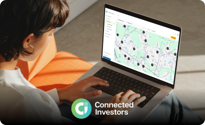 A woman sitting with a laptop looking at the Connected Investor dashboard.